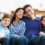 Keluarga berkumpul bersama di ruang tamu, menciptakan ikatan emosional yang positif dan mendukung perkembangan anak