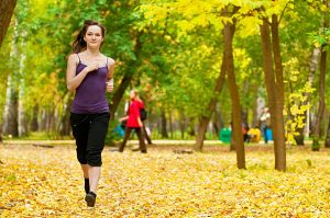 Seorang pelari menikmati suasana alam sambil berlari di taman, menciptakan kebahagiaan dan meredakan stres