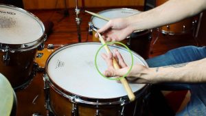Teknik Traditional Grip dalam bermain drum, dengan tangan kiri memegang stik menggunakan posisi khas untuk kontrol yang lebih halus