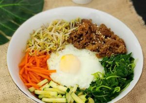 Bibimbap, nasi campur Korea dengan aneka sayuran, daging, telur, dan saus gochujang dalam mangkuk panas