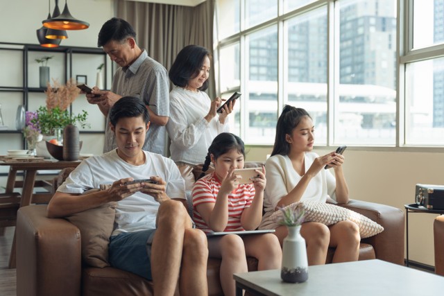 Keluarga sibuk dengan ponsel, menggambarkan dampak media sosial