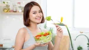 Perempuan muda menikmati salad segar sebagai bagian dari gaya hidup sehat