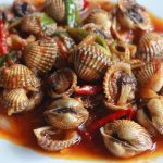 Hidangan kerang pedas sederhana yang dimasak dengan bumbu rumahan, menampilkan warna menggugah selera dari cabai merah dan rempah segar