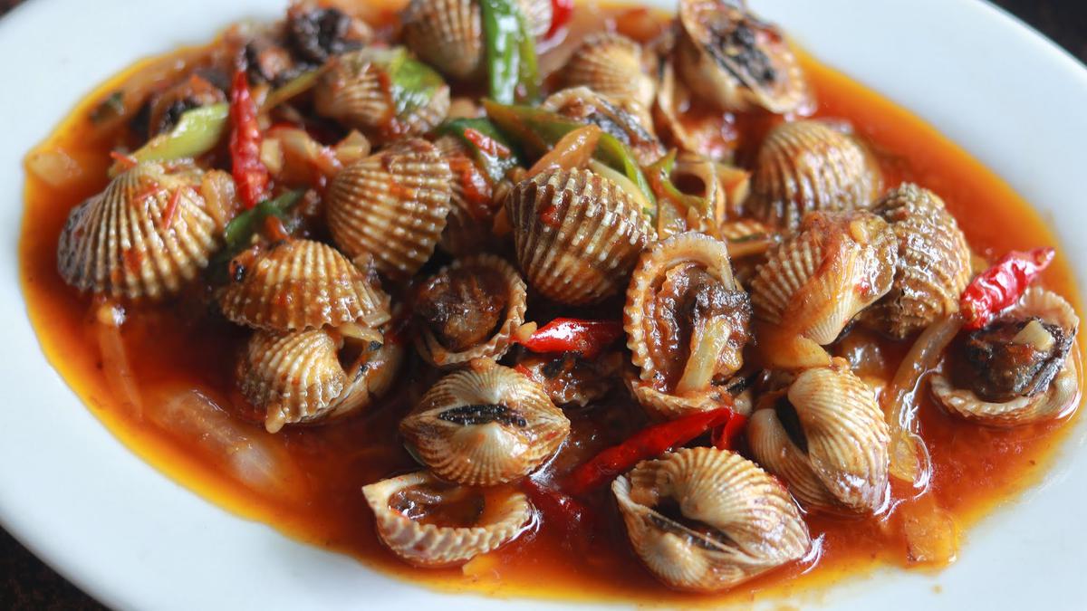 Hidangan kerang pedas sederhana yang dimasak dengan bumbu rumahan, menampilkan warna menggugah selera dari cabai merah dan rempah segar
