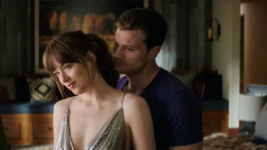 Adegan Christian Grey dan Anastasia Steele di ruang kontrak, dengan ekspresi canggung dan tegang 