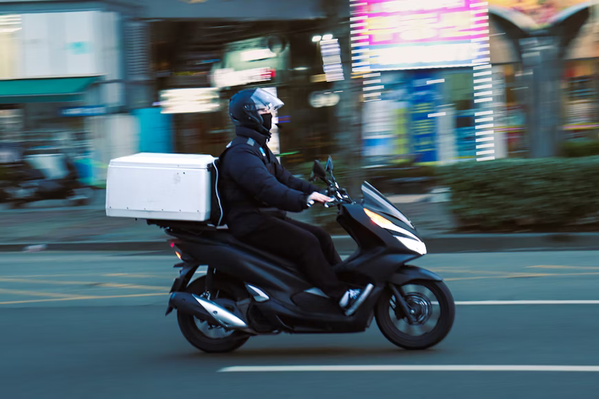 kurir mengantar paket dengan motor pada layanan pengiriman instant