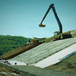 Pekerjaan pemasangan geotextile pada lereng menggunakan alat berat untuk perlindungan erosi