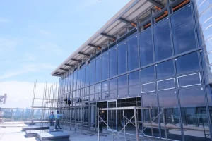 proses pemasangan kaca gedung pada proyek konstruksi
