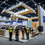 Kontraktor pameran sedang merancang dan membangun booth pameran untuk meningkatkan daya tarik brand di sebuah exhibition